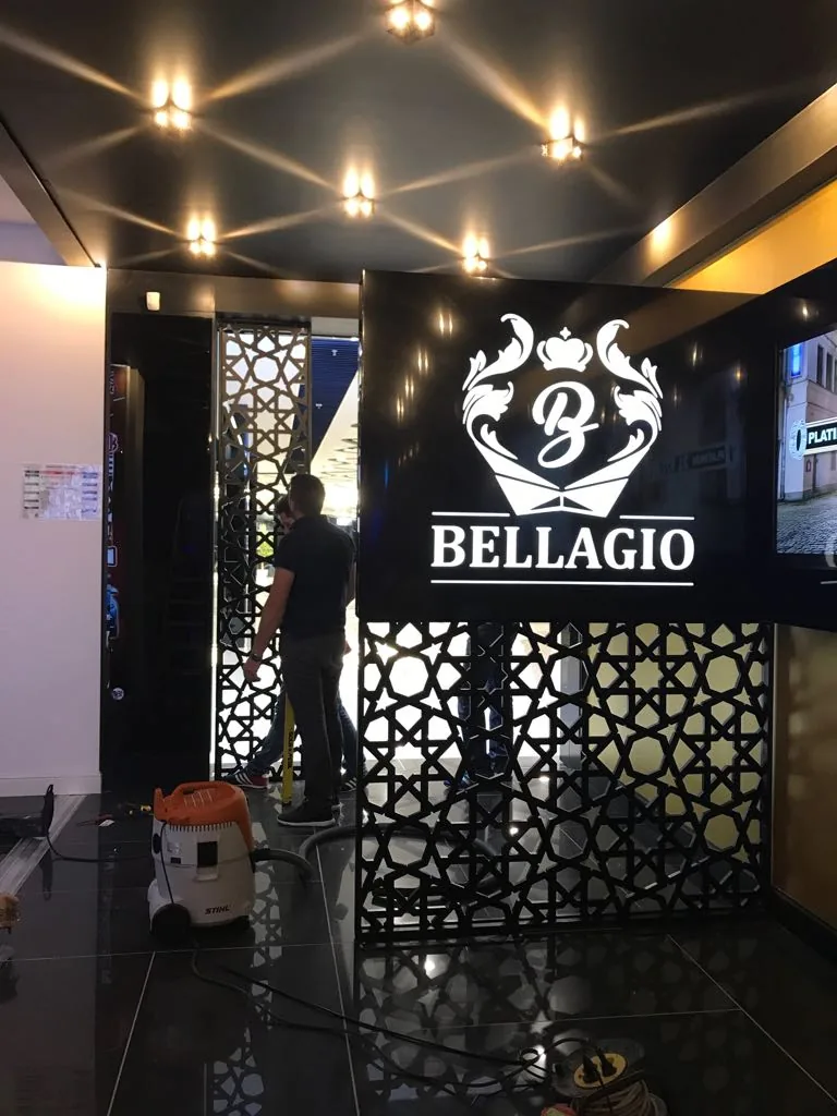 Casetă luminoasă neagră cu logo alb Bellagio, montată în interior