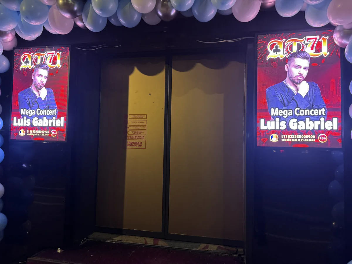 Două ecrane LED verticale montate de o parte și de alta a intrării, afiș de eveniment