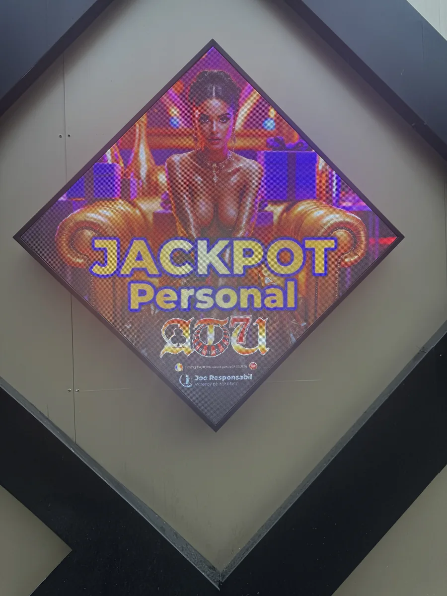Ecran LED în formă de romb, integrat în peretele unei săli de joc, cu afiș Jackpot
